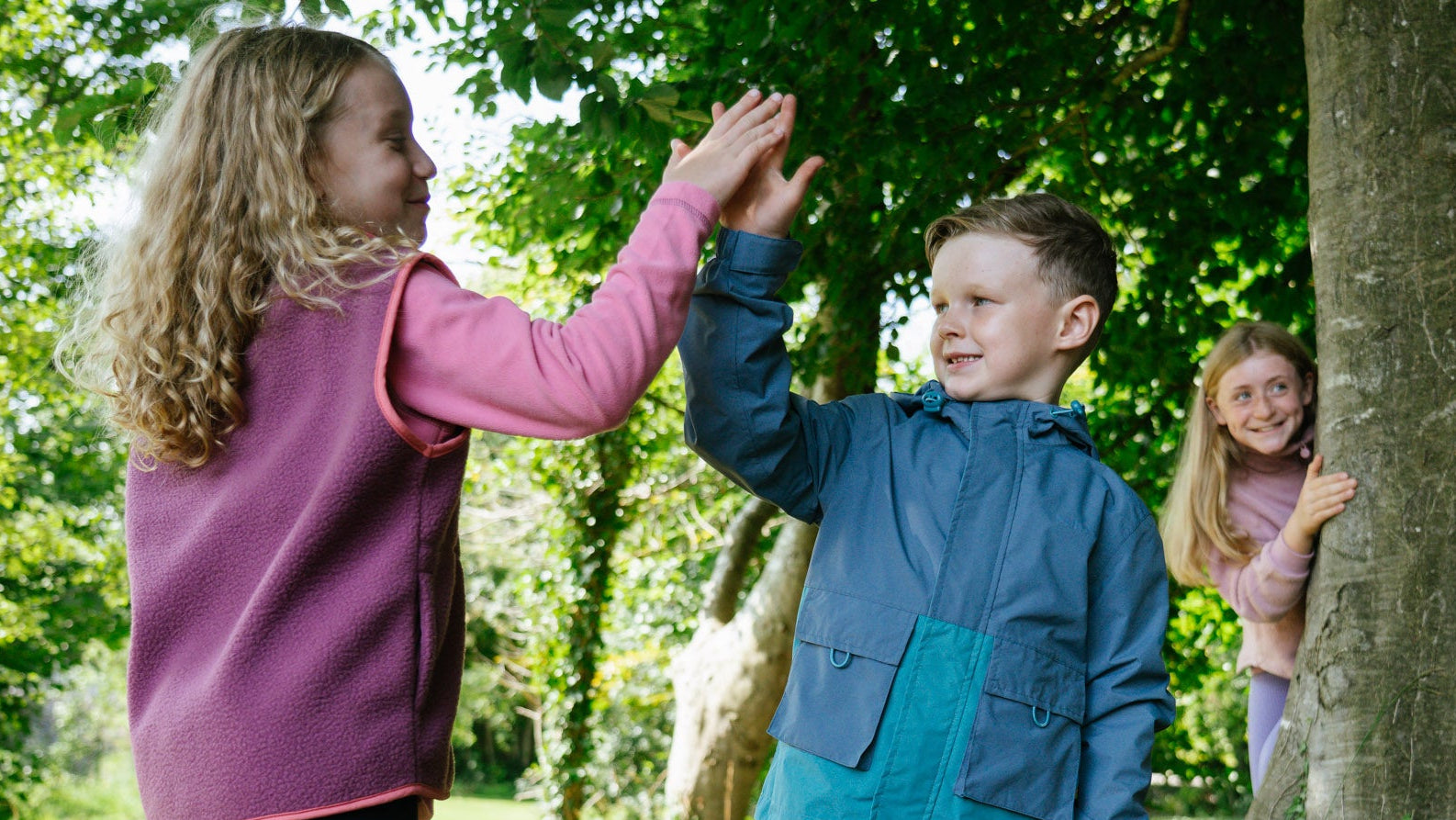 Children wearing Portwest Outdoor Clothing while playing outdoors with a tree in the background